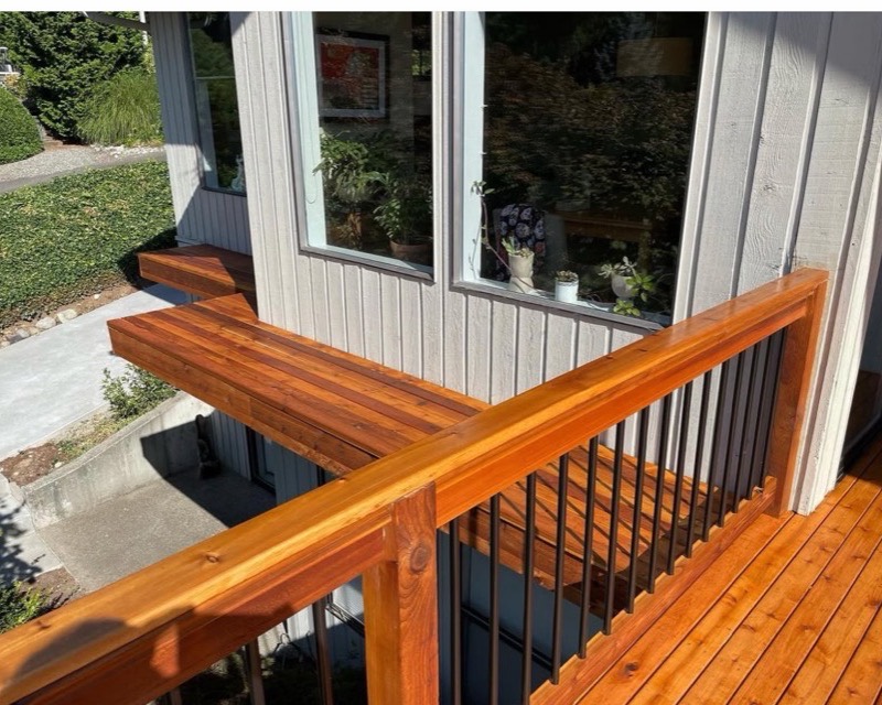 Deck building — freshly stained cedar deck railing and built-in bench in Poulsbo