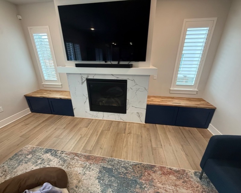 TV mounting — flat-screen over a marble fireplace with custom built-ins in Suquamish